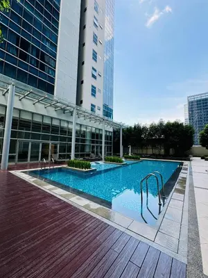 a swimming pool in front of a building at Andi and Frances Place at BGC in Manila