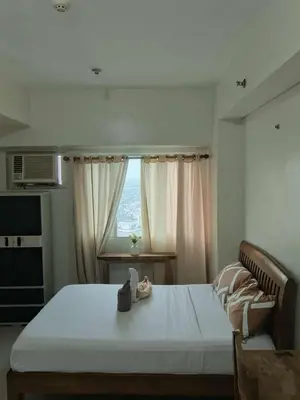 a bedroom with a large bed and a window at The Beacon Makati Condo-Hotel in Manila