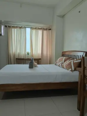 a bedroom with a large bed and a window at The Beacon Makati Condo-Hotel in Manila