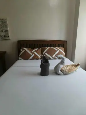 a bed with a hat and a swan on it at The Beacon Makati Condo-Hotel in Manila