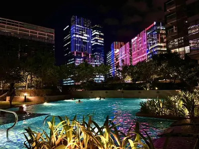a swimming pool in a city at night at Cozy place in Uptown BGC near Malls and clubs in Manila