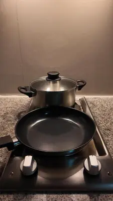 a pot on top of a stove with a pan on it at Cozy place in Uptown BGC near Malls and clubs in Manila