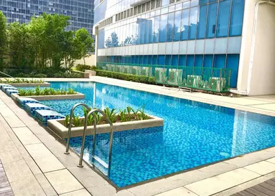 a large swimming pool in front of a building at Cozy place in Uptown BGC near Malls and clubs in Manila