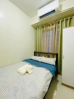a bed with two towels on it in a room at CabinandCo in Manila