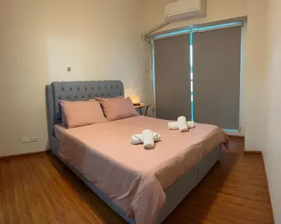 a bedroom with a bed with two towels on it at Amorsolo Tower Makati in Manila