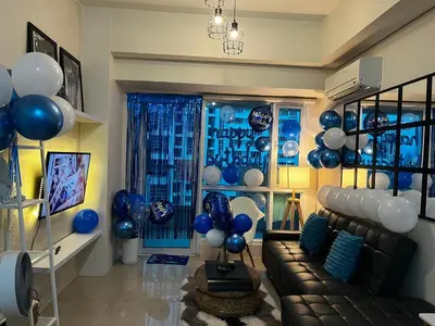a living room with blue and white balloons and a couch at Amorsolo Tower Makati in Manila