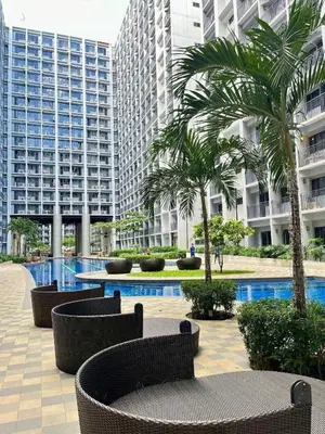 a courtyard with chairs and palm trees in a building at Metro Prime Staycations at Shore 2 Residences T1 in Manila