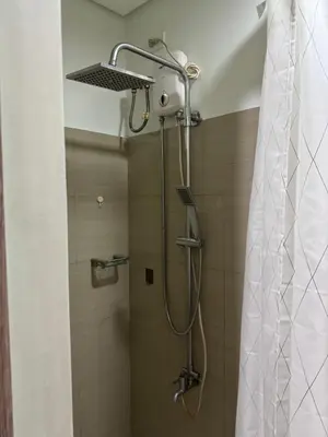 a shower with a shower head in a bathroom at Metro Prime Staycations at Shore 2 Residences T1 in Manila