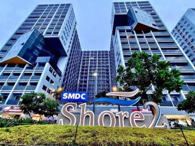 a sign in front of some tall buildings at Metro Prime Staycations at Shore 2 Residences T1 in Manila