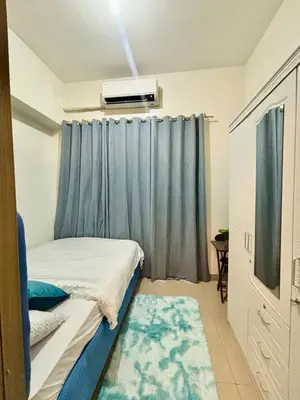 a bedroom with a bed and a blue curtain at Poolside Bliss at Shore 2 in Manila