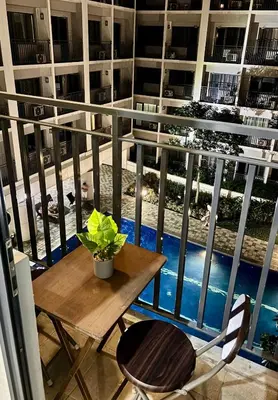 a table and chairs on a balcony with a view of a pool at Poolside Bliss at Shore 2 in Manila
