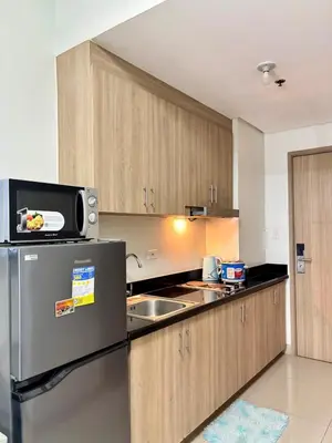 a kitchen with a refrigerator and a microwave at Poolside Bliss at Shore 2 in Manila