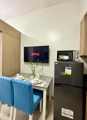 a small kitchen with a table and a refrigerator at Poolside Bliss at Shore 2 in Manila