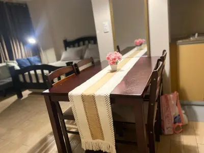 a wooden table with flowers on it in a living room at 3ms and jacob havens in Manila