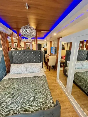 a bedroom with a bed and a mirror at J&J Havenstay Ananda Square in Manila