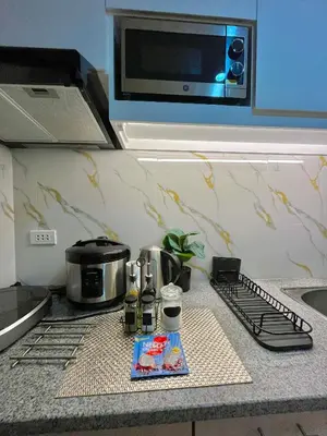 a kitchen counter with a stove and a microwave at J&J Havenstay Ananda Square in Manila