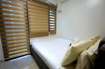 a small bedroom with a bed and a window at Modern Living 6 - MOA Pasay with Wifi and Netflix in Manila