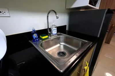 a stainless steel sink in a small kitchen at Modern Living 6 - MOA Pasay with Wifi and Netflix in Manila