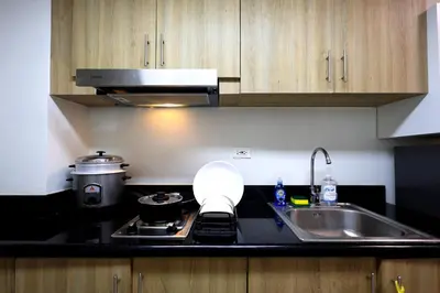 a kitchen with a sink and a stove with a bowl on it at Modern Living 6 - MOA Pasay with Wifi and Netflix in Manila