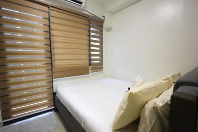 a small bedroom with a bed and a window at Modern Living 6 - MOA Pasay with Wifi and Netflix in Manila