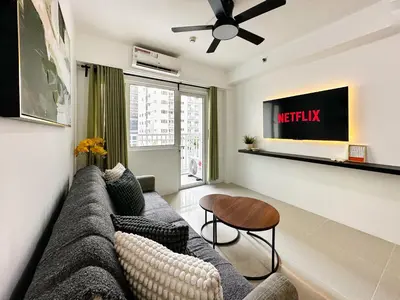 a living room with a couch and a table at Spacious 2BR Living Rm Shore Res near NAIA MOA in Manila