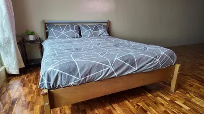 a bed with a gray comforter in a bedroom at Monitor Gear Residences in Manila