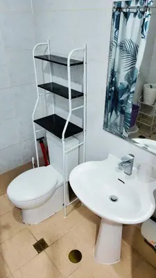 a bathroom with a white toilet and a sink at Monitor Gear Residences in Manila