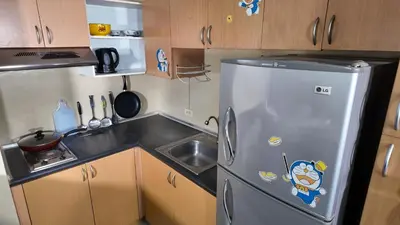 a small kitchen with a stainless steel refrigerator at Monitor Gear Residences in Manila