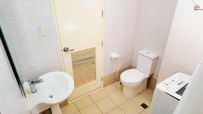 a bathroom with a toilet and a sink and a shower at Monitor Gear Residences in Manila
