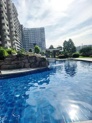 a large swimming pool in a city with tall buildings at Minimalist stay in Satori Residences Pasig City in Manila