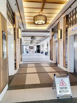 a hallway in a building with a caution sign on the floor at Minimalist stay in Satori Residences Pasig City in Manila