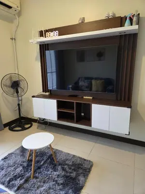 a living room with a large entertainment center with a television at Minimalist stay in Satori Residences Pasig City in Manila
