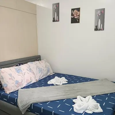 a bedroom with a bed with two towels on it at Grace era Staycation in Manila