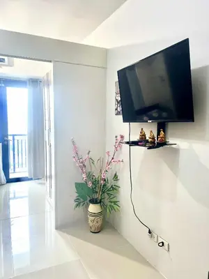 a living room with a flat screen tv on a wall at Grace era Staycation in Manila