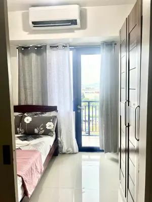 a small bedroom with a bed and a window at Grace era Staycation in Manila