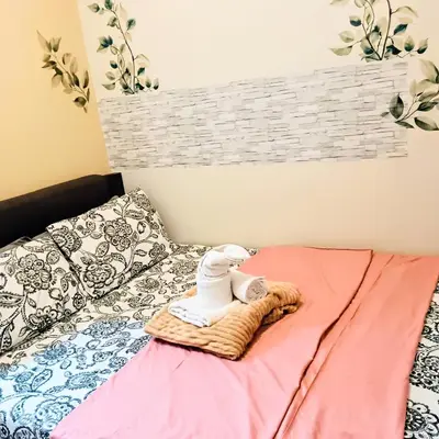 a bed with a towel and a stuffed animal on a blanket at Grace era Staycation in Manila