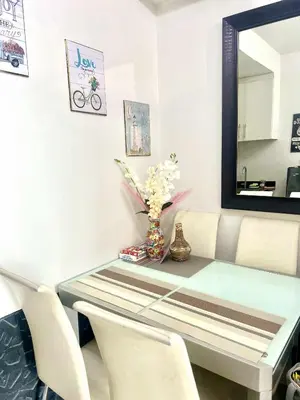 a dining room table with a mirror and a vase of flowers at Eden Era staycation in Manila