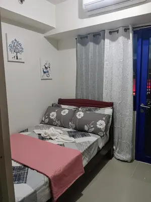 a small bedroom with a bed and a window at Eden Era staycation in Manila