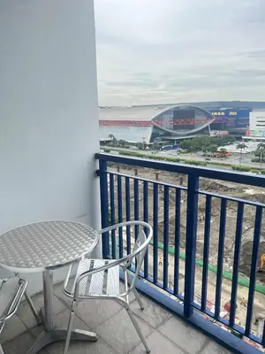 a balcony with a table and chairs and a view of a stadium at Eden Era staycation in Manila