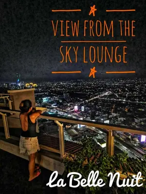 a person standing on the top of a tower at night at Prisma La Belle Nuit in Manila