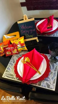 a table with a plate with a red napkin and a spoon at Prisma La Belle Nuit in Manila