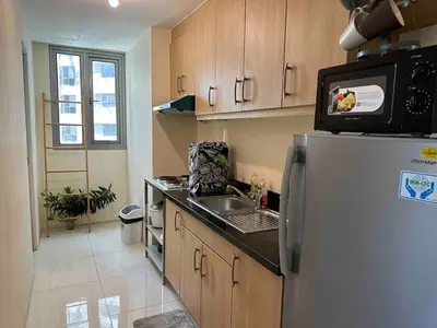 a kitchen with a refrigerator and a sink at 55-SQM 1-BR golf club view condo in Central BGC in Manila