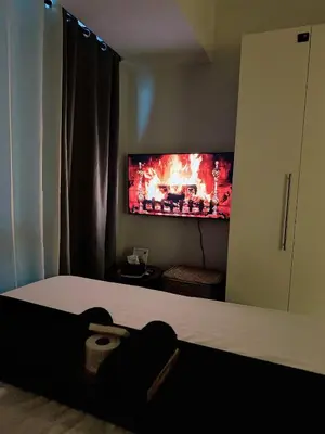 a bedroom with a bed with a tv on the wall at Stunning 42nd Floor Apt with Netflix in Manila