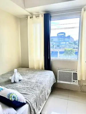 a small bedroom with a bed and a window at Vince era staycation in Manila