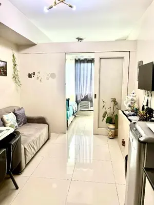 a living room with a couch and a kitchen at V&G era staycation in Manila
