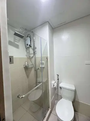 a bathroom with a toilet and a glass shower at Bloom Residence by SMDC in Manila