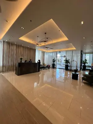 a large lobby with a reception desk in a building at Bloom Residence by SMDC in Manila