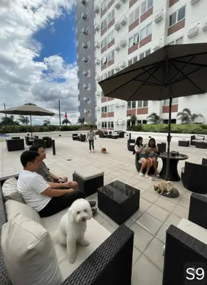 a group of people sitting on a patio with a white dog at S-Line - Your place, your comfort! in Manila