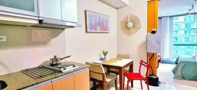 a kitchen with a table and a counter top at Explore Mitsukoshi BGC with pool and wifi in Manila