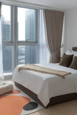 a bedroom with a large white bed with windows at Cozy 1-Bedroom in Uptown Parksuites BGC in Manila